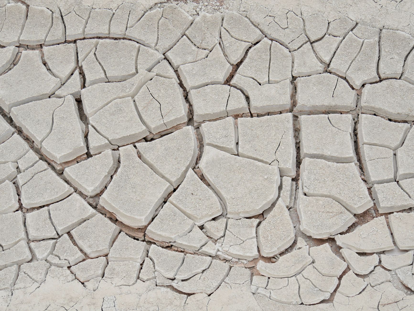 Close-up of cracked, dry earth depicting drought in an arid region, highlighting climate change and water scarcity.